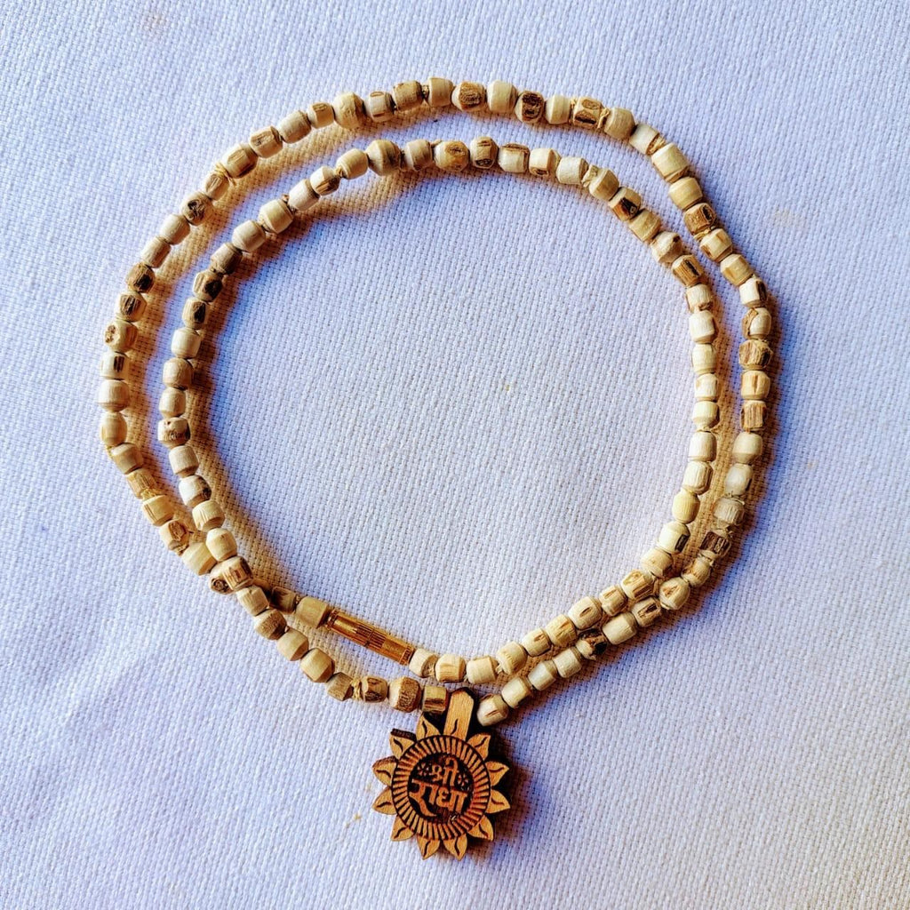 Handcrafted Tulsi Mala featuring a distinctive Radha Name Pendant, combining spiritual significance with elegant design. The sacred Tulsi beads are meticulously strung to provide durability while honoring traditional craftsmanship. This devotional accessory serves as both a meaningful religious symbol and a refined personal adornment for spiritual practitioners.