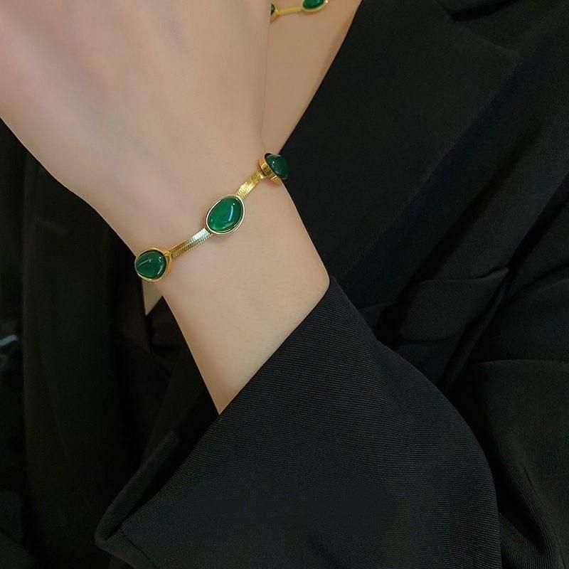 Expertly crafted, this Oval Green Crystal Pendant Necklace Set with Bracelet is a must-have accessory. Featuring a stunning green crystal pendant and matching bracelet, this set adds a touch of elegance to any outfit. Handmade with precision, this set is sure to make a statement.