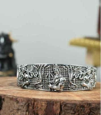 This men's oxidised silver Mahakal bracelet is a sophisticated and unique accessory. Crafted with expert precision and detailed design, it features a strong and masculine oxidised silver finish. Perfect for both casual and formal occasions, this bracelet adds a touch of edge and style to any outfit.