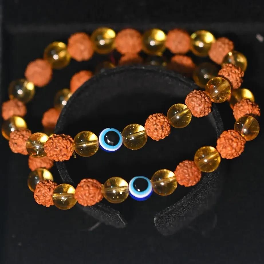 Rudraksha Citrine Crystal Bracelet (Pack of 2)

Harness the ancient power of Rudraksha beads combined with energy-enhancing Citrine crystals in this authentic bracelet set. Each pack contains two meticulously crafted bracelets designed to promote spiritual balance, prosperity, and positive energy flow. The natural variations in these sacred materials ensure each bracelet is uniquely yours, making them perfect for personal use or as meaningful gifts for those on a spiritual journey.